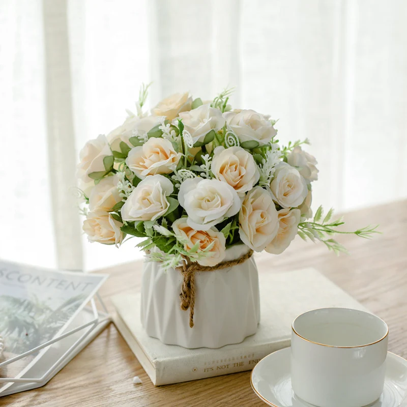 Seidenblumenarrangement in einem mit Schnur umwickelten Keramikpflanzer als Tischmittelpunkt