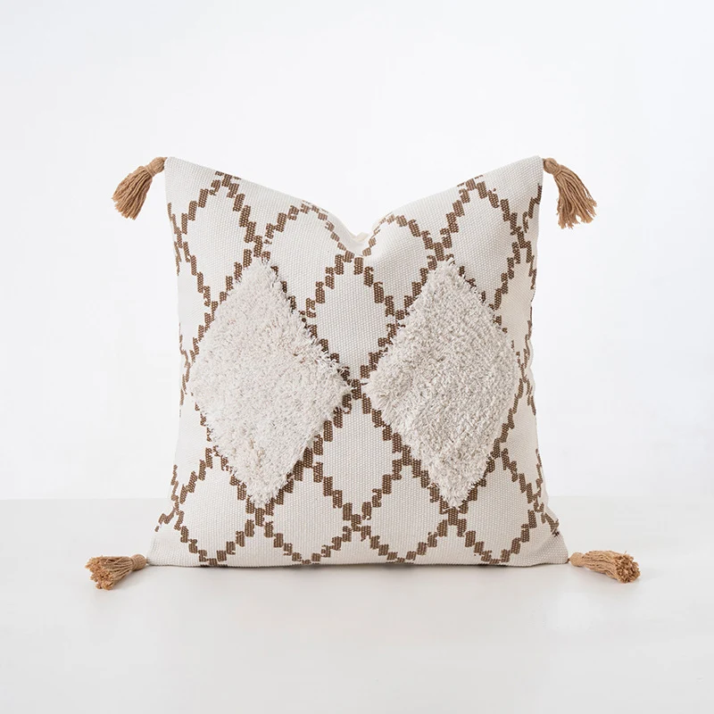 Quadratisches Dekokissen mit Bouclé-Relief, Zickzack- und Rautenmuster sowie Quasten