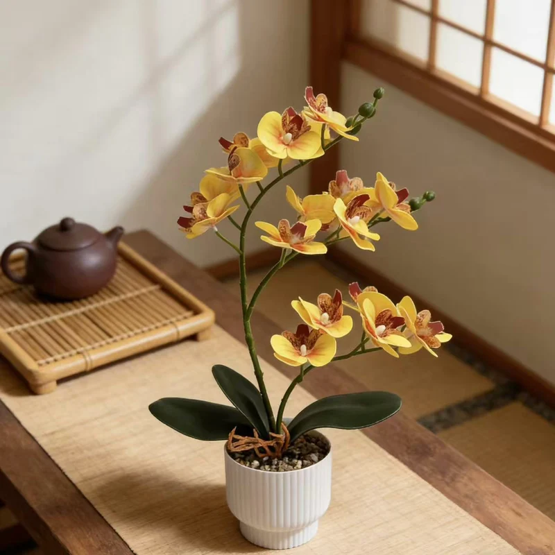 Realistische künstliche Orchideenpflanze mit dekorativem Topf
